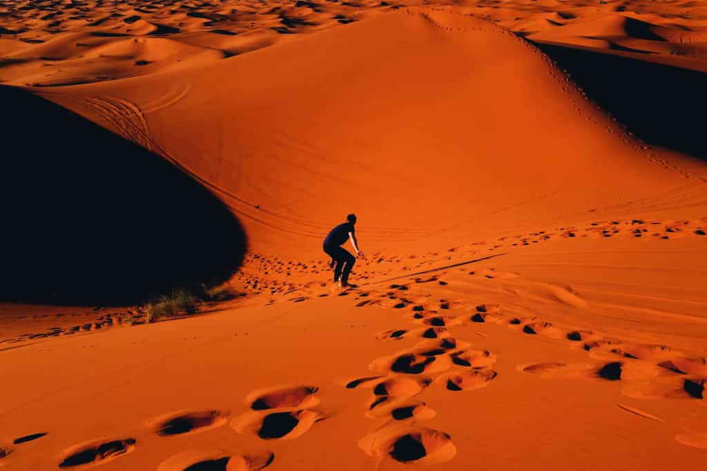 Parcticar sandboard en tu viaje a Merzouga, desierto de Marruecos