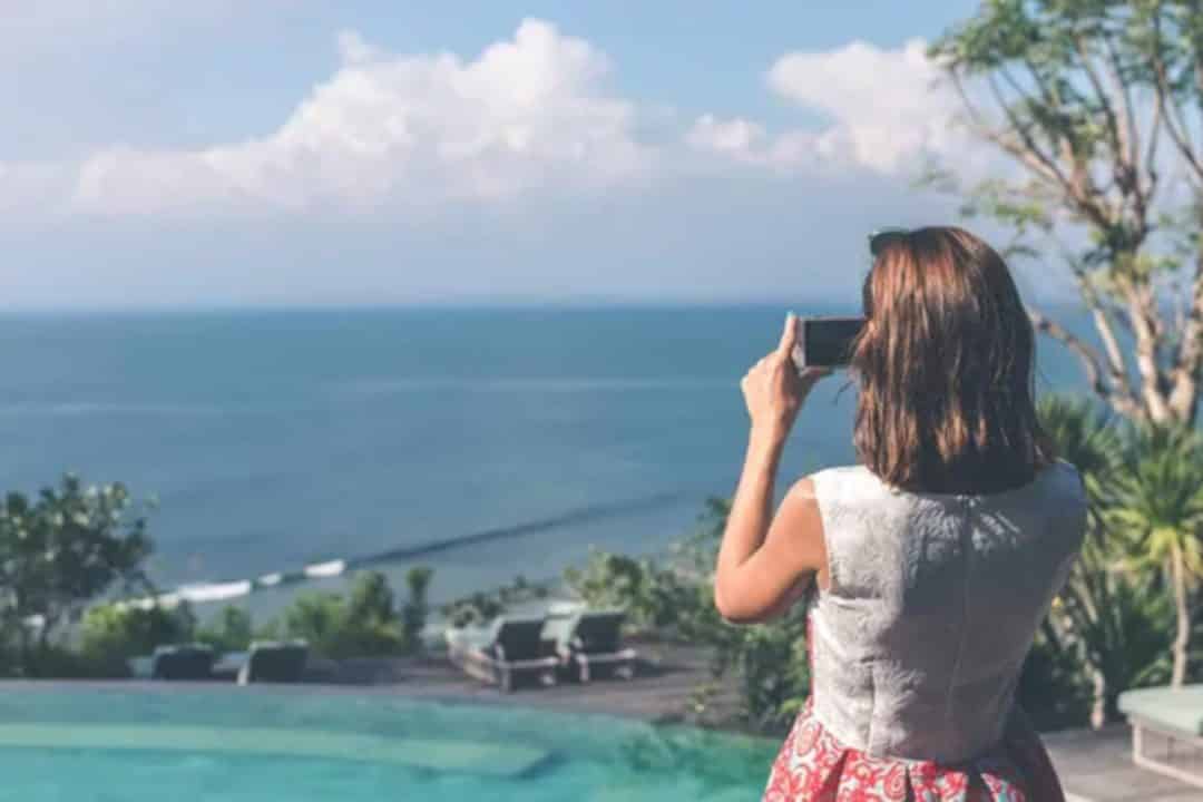 Jeune femme prenant en photo la mer