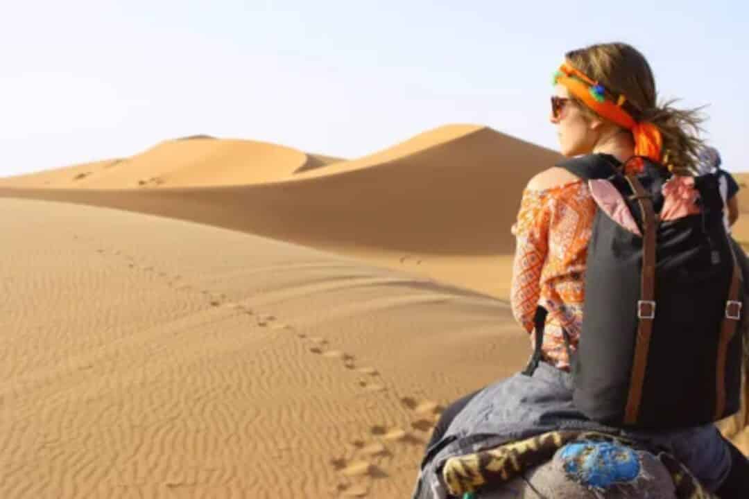 Femme avec un sac au Maroc à dos de chameau
